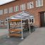 Skydd för cyklar Rower Cykelgarage framför en byggnad.