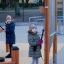 Två barn spelar på Klockspel lekplatsinstrument.