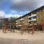 Stor lekstruktur Myrstack med Nät på en sandig lekplats framför ett bostadshus.