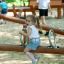 Flicka leker på Seesaw Nature lekplatsutrustning.
