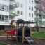 Lekplatsutrustning Lok framför bostadsbyggnader.