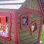 Barn leker i rött och brunt lekhus från Anna's Playhouse