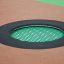 Rund trampolin (100 cm) infälld i lekplatsens yta med svart kant och grön studsmatta.
