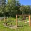 Träningsbana för barn i en lekpark med gröna träd i bakgrunden.