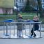 Tillgänglig karusell för rullstol (2-person) på lekplats med två barn som leker.