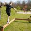 Barn leker på Trim Trail Line balansbom på en lekplats.