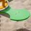 Grön sittplats av Clover Spring Rider (2 Seats) över sand.
