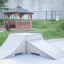 Skateboardramp i en park med ett träpaviljong i bakgrunden.