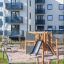 Lekutrustning Klätterkiosk Natur på lekplats framför flerfamiljshus.