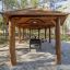 Paviljong Grillhus Natur i trä med grillplats i skogsmiljö.