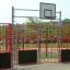 Bjärevallen basketbollplan med röda staket och korg på utomhuslekplats.