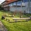 Lekplatsutrustning Balansbana Sahara framför en skolbyggnad.
