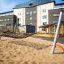 Hammock stål monterad på lekplats nära modern skolbyggnad.