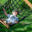 Pojke som ligger och vilar i Hammock Natur Robinia.