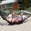 Barn leker i en Hammock Natur Robinia hängmatta på en lekplats.