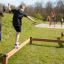 Pojkar balanserar på Classic Nature Trim Trail i en lekpark.