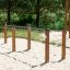 Gymnastikbarr utomhus på sandig mark i parkområde.