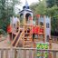 Lekplats Camelot, komplett friluftslekplats med klätterställning och torn i en trädfylld park.