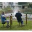 Personer som använder Sittande Höftträning i en park bredvid en fontän.