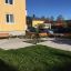 Bänk med Armstöd utomhus vid en modern bostadsbyggnad.