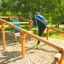 Två personer använder Balansgång på höjd utomhus i en park.