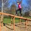 Kvinna balanserar på Balansgång på höjd i en park.