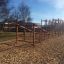 Lekställning Balansgång på höjd i en park med träflis på marken.