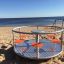 Lekställningen Karusell på en sandstrand vid havet.