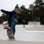 Pojke åker skateboard på en Hörnramp i en skatepark.