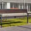 Råå Soffa i modern design på en stenlagd trottoar, med en gräsmatta och byggnad i bakgrunden.