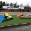 Färgglada Lounge Solstolar på konstgräs vid skolgård.