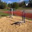 Utomhus gymutrustning Pull Down + Chest Press nära en löparbana.